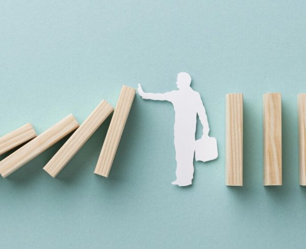 Sombra branca de homem segurando peças caindo em simbologia à gestão de crise